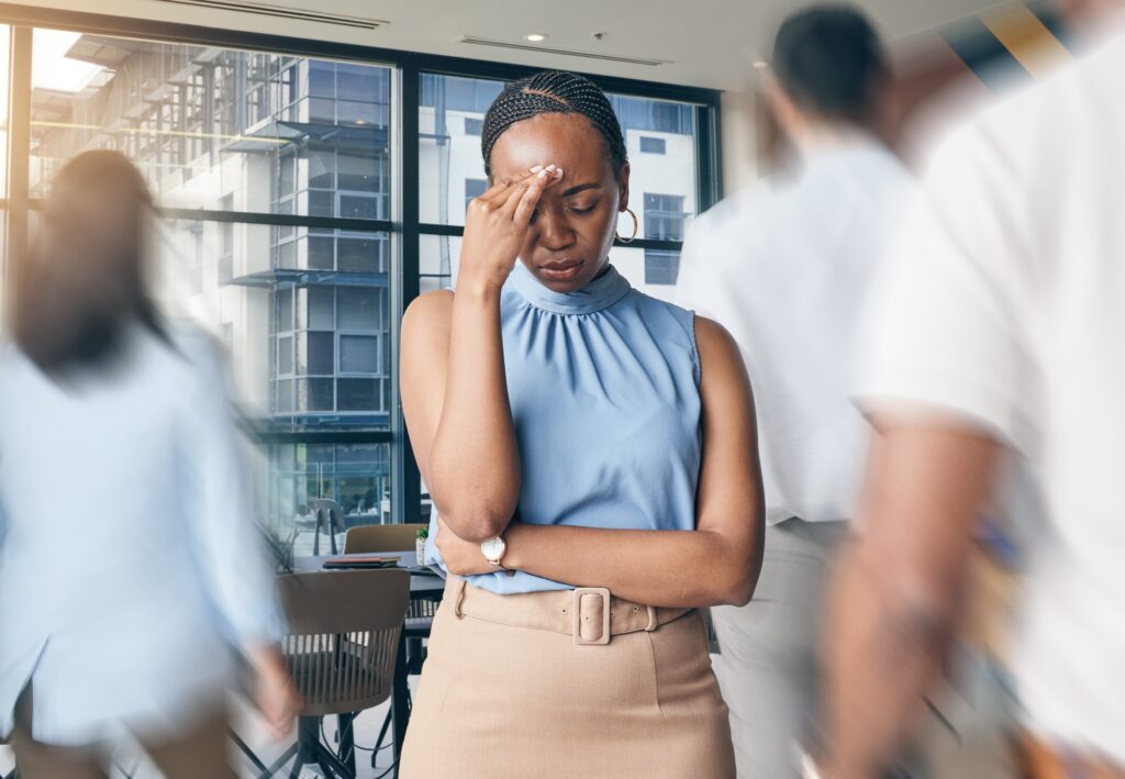 Busy office, people and a black woman with a headache, workplace stress or burnout from chaos. Tire