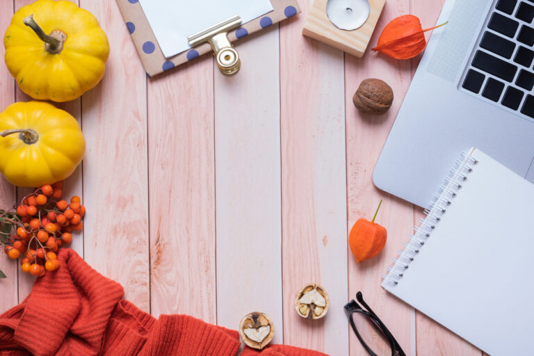 Frame made from note pad, laptop, sweater and pumpkins on wooden