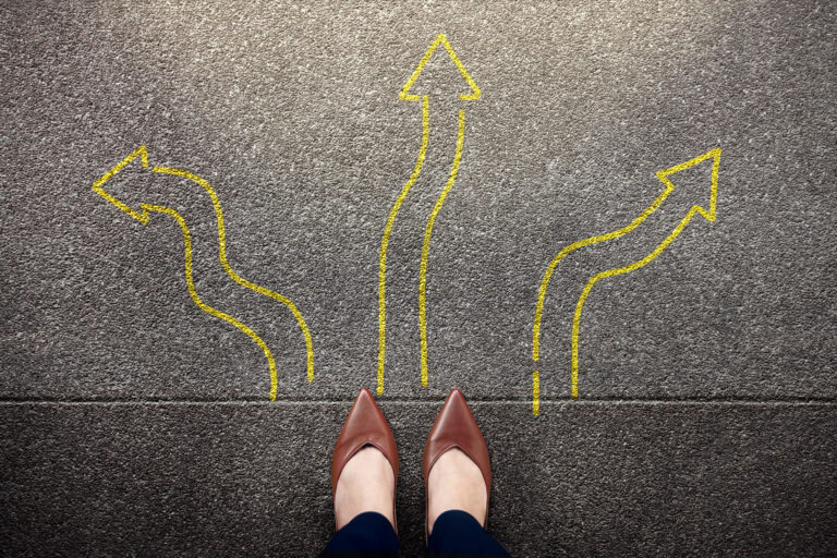Feet standing among many drawn arrows, symbolizing decision